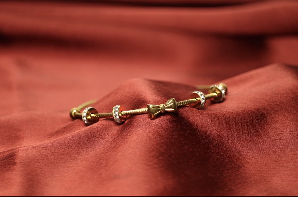 Gold Twisted Cable Bangle | CZ Studded Bow Charm Bracelet